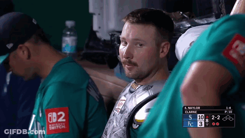 A Man Wearing A Green Shirt That Says Nintendo Switch Sits In A Dugout GIF
