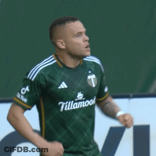 A Man Wearing A Green Shirt That Says ' Tourism ' On The Sleeve GIF