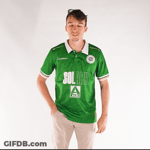 A Man Wearing A Green Solary Shirt Stands With His Eyes Closed GIF