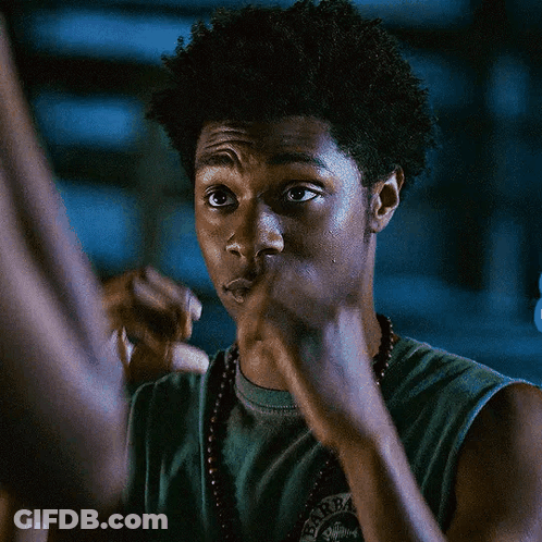 A Man Wearing A Green Tank Top And A Necklace Covering His Mouth With His Hands GIF