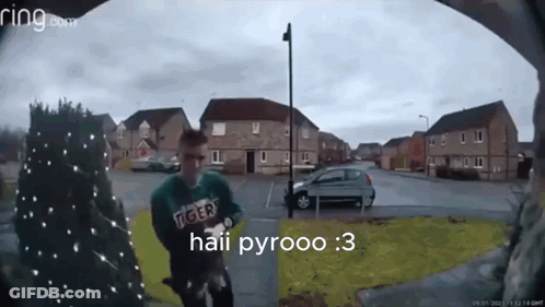 A Man Wearing A Green Tiger Sweatshirt Is Standing In Front Of A Ring Doorbell GIF