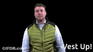 A Man Wearing A Green Vest With The Words Vest Up Behind Him GIF