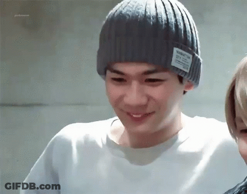 A Man Wearing A Grey Beanie With A Manhattan City Logo On It GIF