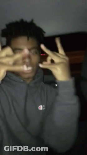 A Man Wearing A Grey Champion Hoodie Makes A Peace Sign GIF