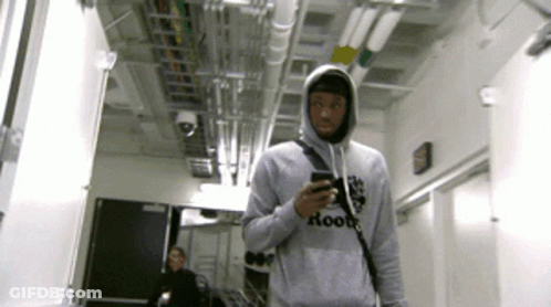 A Man Wearing A Grey Hoodie That Says Roots On It GIF
