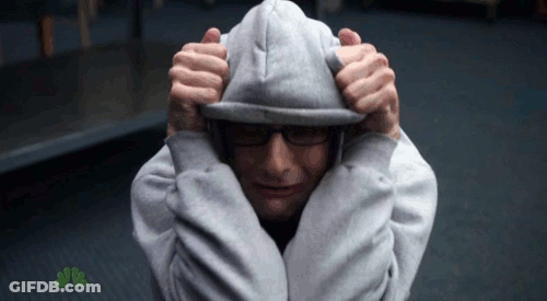 A Man Wearing A Grey Hoodie With A Nbc Logo Behind Him GIF