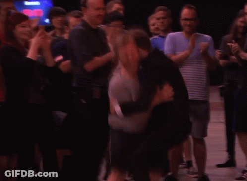 A Man Wearing A Grey Shirt That Says ' Tivoli ' On The Front GIF