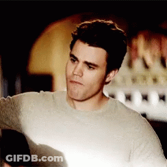 A Man Wearing A Grey Sweater Looks At Something GIF