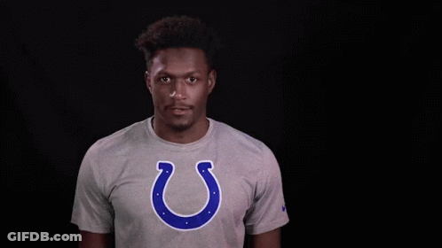 A Man Wearing A Grey T-Shirt With A Horseshoe On It GIF