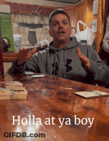 A Man Wearing A Grey Under Armour Sweatshirt Sitting At A Table GIF