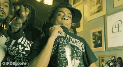 A Man Wearing A Guess T-Shirt Smoking A Cigarette GIF