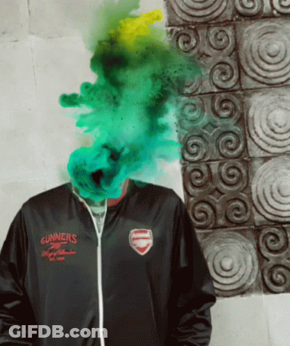 A Man Wearing A Gunners Jacket Has Green Smoke Coming Out Of His Face GIF