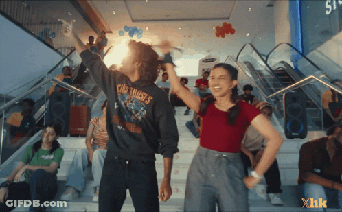 A Man Wearing A Guns N ' Roses Shirt Is Standing Next To A Girl GIF