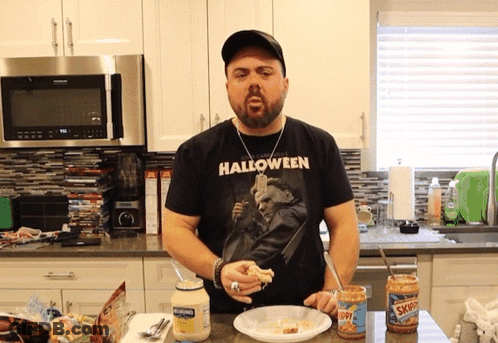 A Man Wearing A Halloween T-Shirt Is Cooking GIF