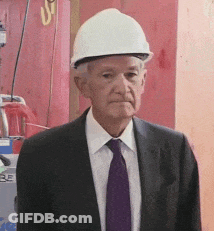 A Man Wearing A Hard Hat And A Suit GIF