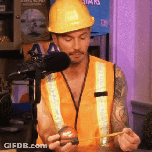 A Man Wearing A Hard Hat And Safety Vest Is Measuring Something GIF