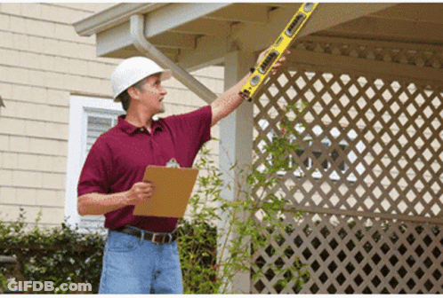 A Man Wearing A Hard Hat Is Holding A Level That Says ' Stanley ' On It GIF