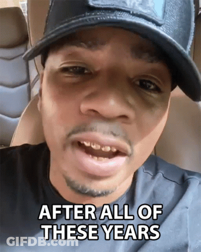 A Man Wearing A Hat And A Black Shirt Says After All Of These Years GIF