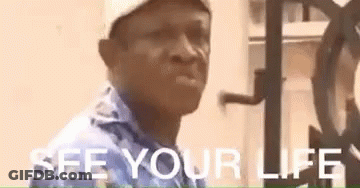 A Man Wearing A Hat And A Blue Shirt Is Standing In Front Of A Clock And Says `` See Your Life '' . GIF