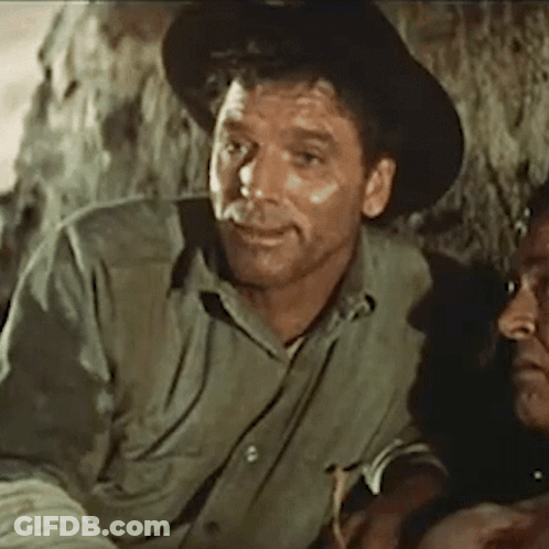 A Man Wearing A Hat And A Green Shirt Is Sitting Next To Another Man GIF