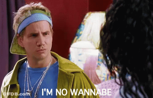 A Man Wearing A Hat And A Headband Says I 'M No Wannabe . GIF