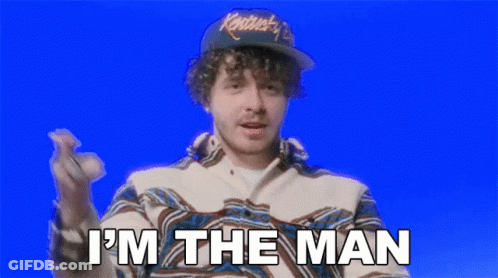 A Man Wearing A Hat And A Jacket Is Saying `` I 'M The Man '' While Holding A Baseball . GIF