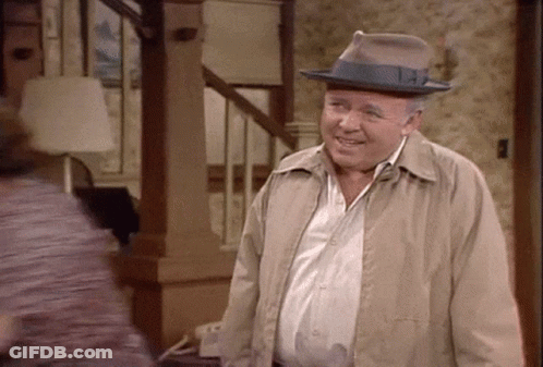 Man Smiling In Living Room With Hat And Jacket GIF