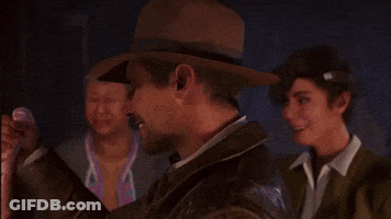A Man Wearing A Hat And A Jacket Is Smiling In Front Of Two Other Men . GIF