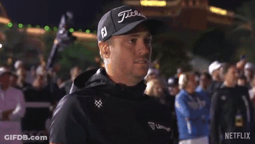 A Man Wearing A Hat And A Jacket Is Standing In Front Of A Crowd Of People . GIF