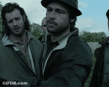 A Man Wearing A Hat And A Jacket Is Standing Next To Another Man GIF