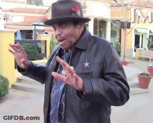A Man Wearing A Hat And A Leather Jacket Has A Star On His Chest GIF