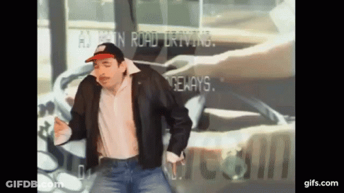A Man Wearing A Hat And A Leather Jacket Is Dancing In Front Of A Sign That Says ' A ' On It GIF