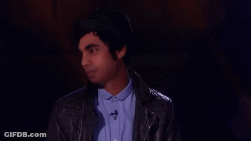 Man In Hat And Leather Jacket Standing In Darkness GIF