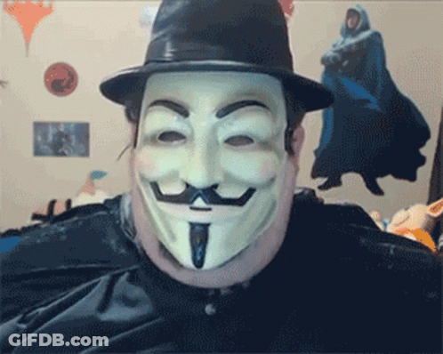 A Man Wearing A Hat And A Mask Looks At The Camera GIF