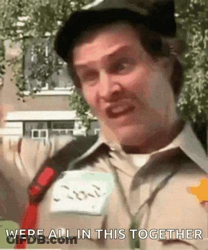A Man Wearing A Hat And A Name Tag With The Words Were All In This Together Written On It GIF