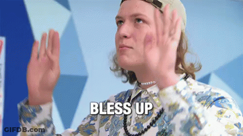 A Man Wearing A Hat And A Necklace Is Giving A High Five And Says Bless Up GIF