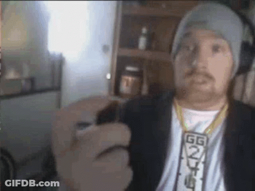 A Man Wearing A Hat And A Necklace Is Holding A Lighter In His Hand . GIF