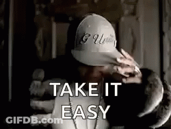 A Man Wearing A Hat And A Necklace Is Holding A Stuffed Animal And Saying `` Take It Easy '' . GIF