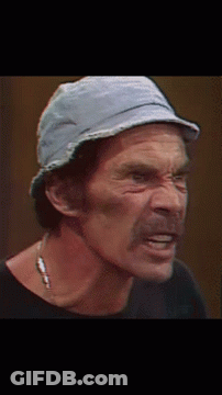 A Man Wearing A Hat And A Necklace Looks Down GIF
