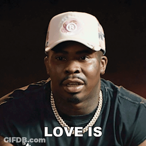 A Man Wearing A Hat And A Necklace Says " Love Is " GIF