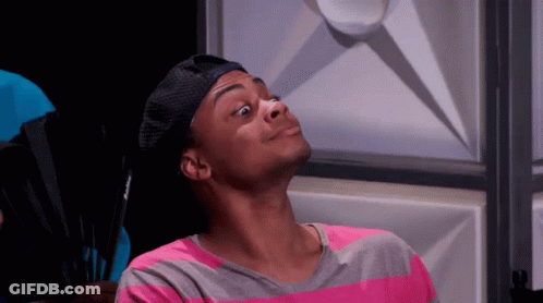 A Man Wearing A Hat And A Pink And Gray Striped Shirt Is Making A Face . GIF