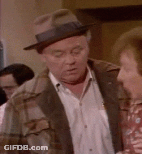 Man In Hat And Plaid Jacket Talking To Woman GIF