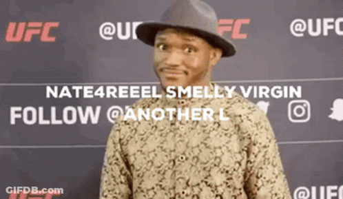 A Man Wearing A Hat And A Shirt Is Standing In Front Of A Ufc Sign . GIF