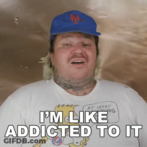 A Man Wearing A Hat And A Shirt That Says I 'M Like Addicted To It On It GIF