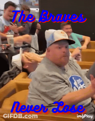 A Man Wearing A Hat And A Shirt That Says The Braves GIF