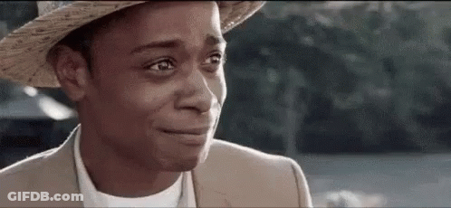 A Man Wearing A Hat And A Suit Is Crying With His Eyes Closed . GIF
