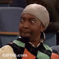 A Man Wearing A Hat And A Sweater Is Making A Funny Face While Sitting In A Classroom . GIF