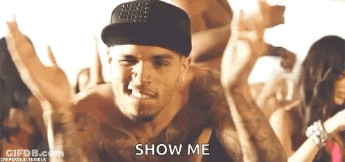 A Man Wearing A Hat And A Tank Top Is Dancing In Front Of A Crowd And Says `` Show Me '' . GIF