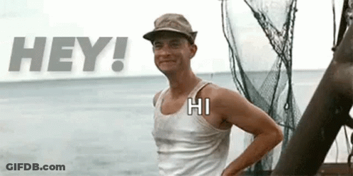 A Man Wearing A Hat And A Tank Top Is Standing In Front Of A Boat In The Ocean . GIF