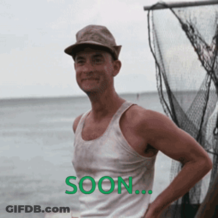 A Man Wearing A Hat And A Tank Top Is Standing In Front Of A Body Of Water With The Word Soon Written On The Bottom GIF